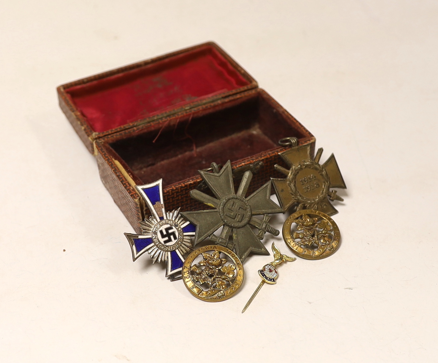 A WW1 Hindenburg Honour Cross A WW2 Silver German Mothers Cross showing some damage (for producing 6 or more children), a WW2 bronze Military War Merit Cross (with Swords) a small RAFA lapel badge, two gilt? badges comme